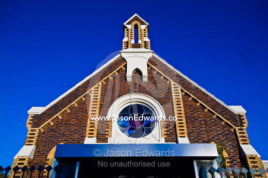 The facade and steeple of a Victorian church converted to apartments. Carlton North, Victoria, Australia