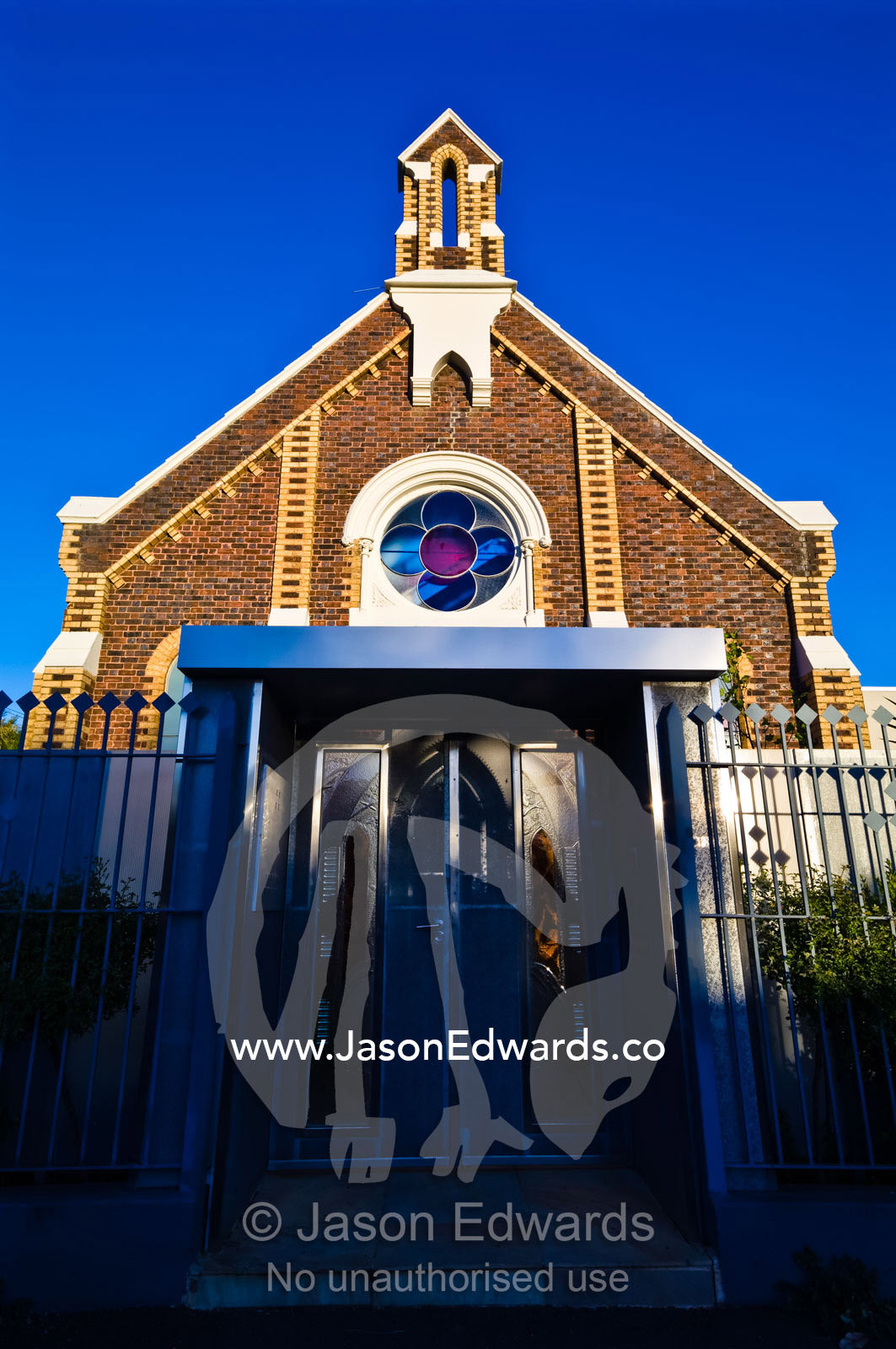 The facade and steeple of a Victorian church converted to apartments. Carlton North, Victoria, Australia