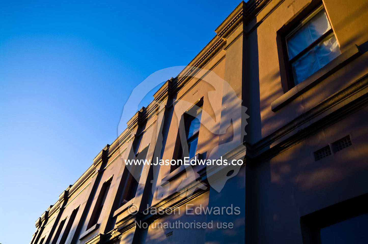 Sunset catches the ornate facade and windows of a Victorian restaurant Carlton North, Victoria, Australia