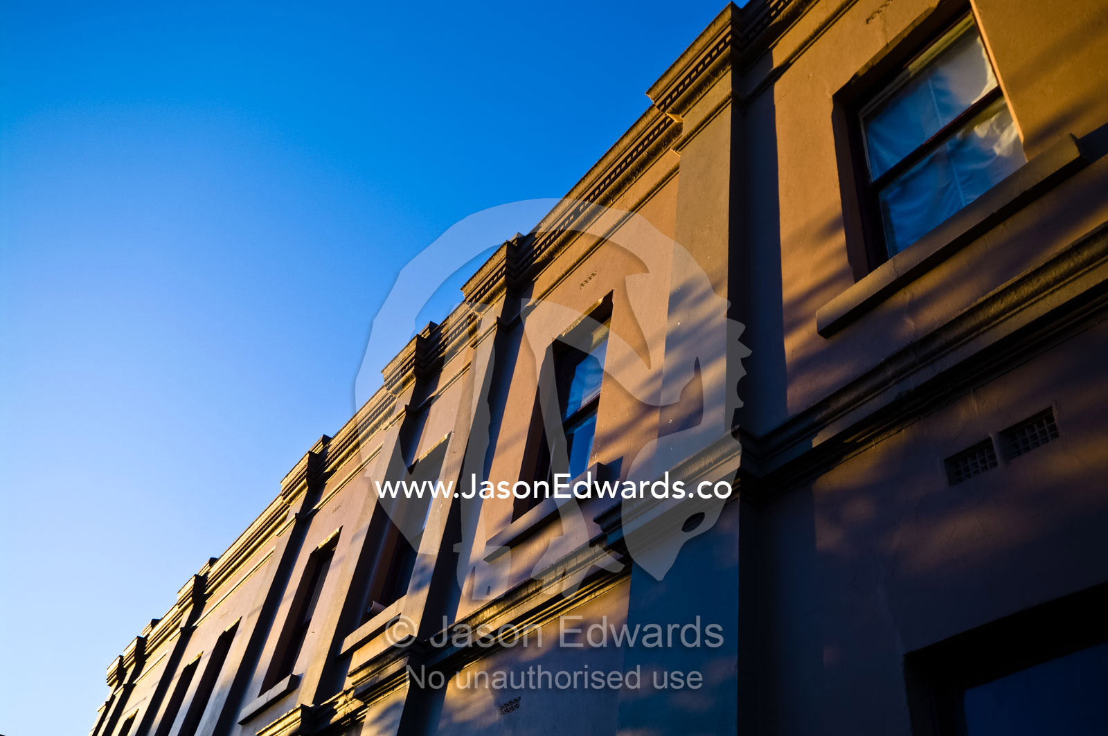 Sunset catches the ornate facade and windows of a Victorian restaurant Carlton North, Victoria, Australia