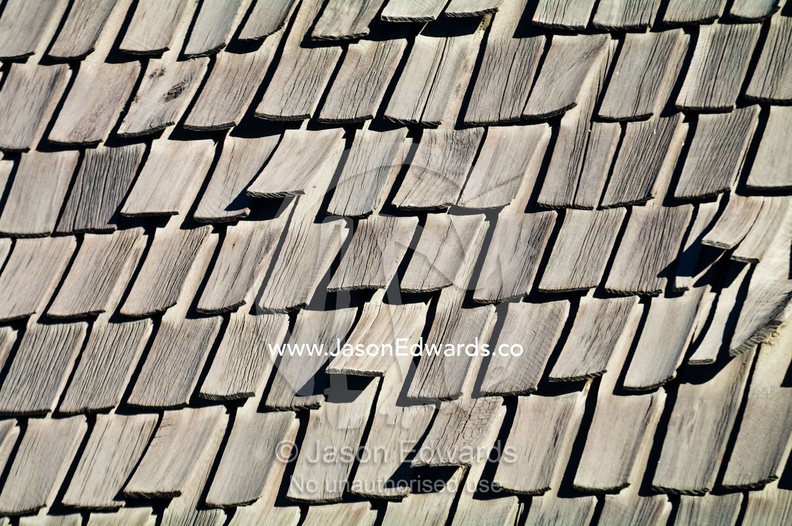 Weathered timber tiles start to lift from an old roof. Providencia District, Santiago, Chile