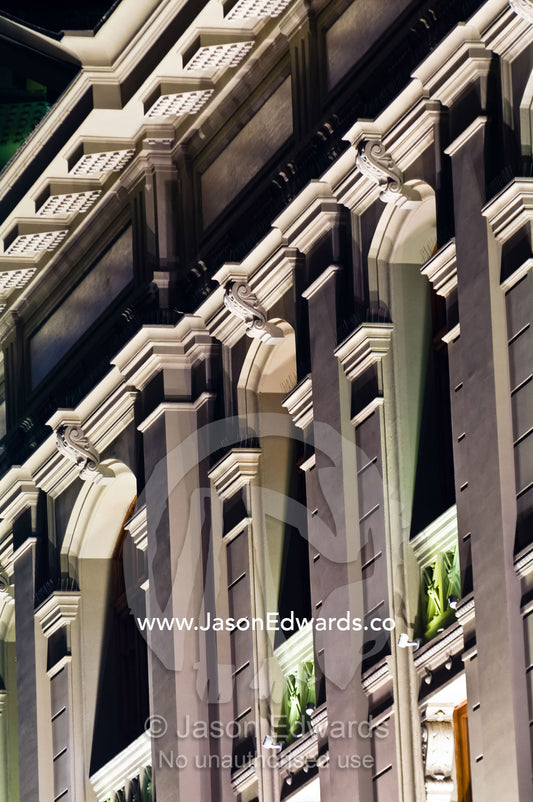 An ornate neo-classical facade etched in deep relief by street lights. Ministerio de Justicia, Santiago, Chile
