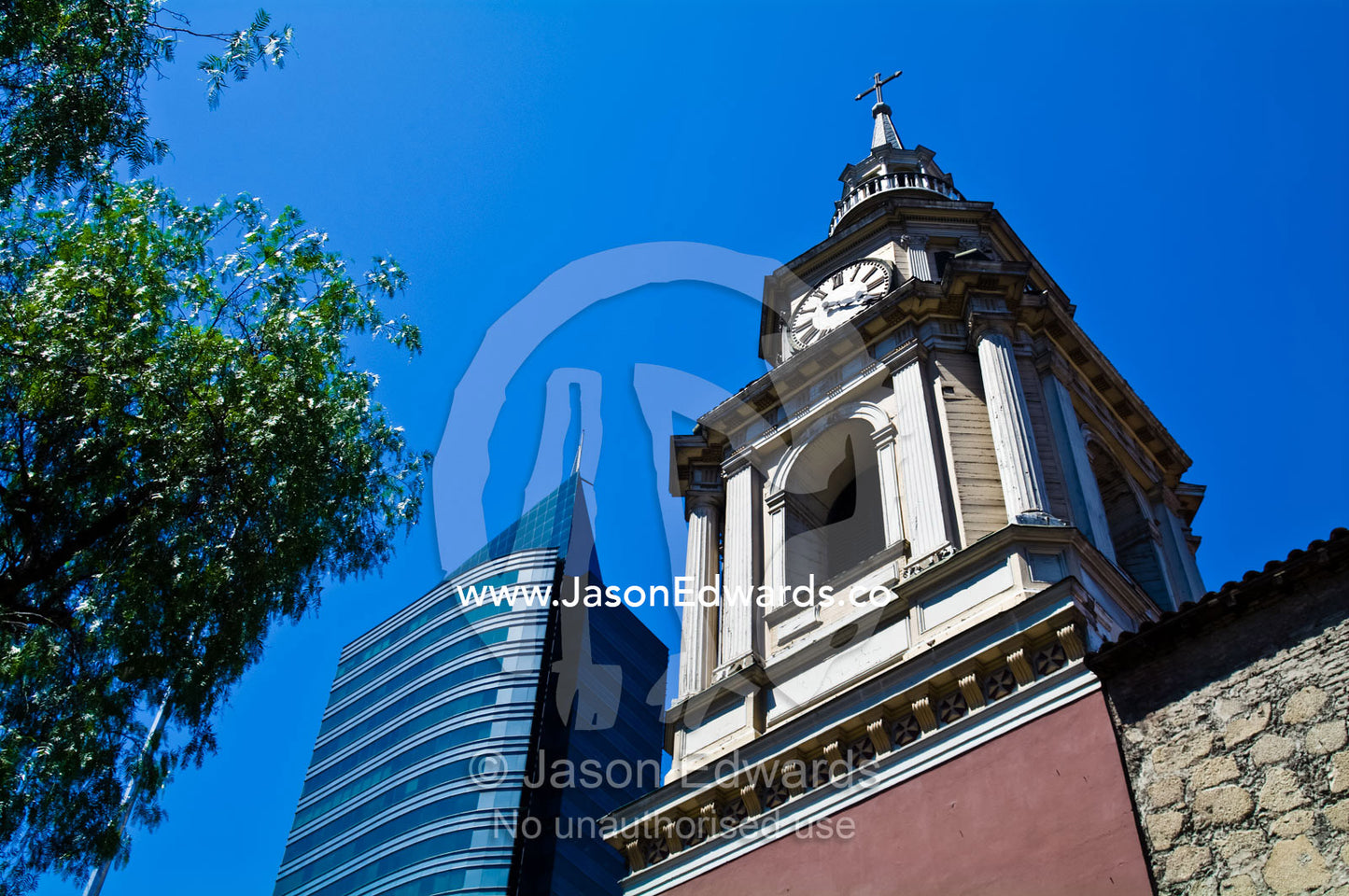 An ancient Christian church steeple alongside a modern office complex. Iglesia San Francisco, Santiago, Chile
