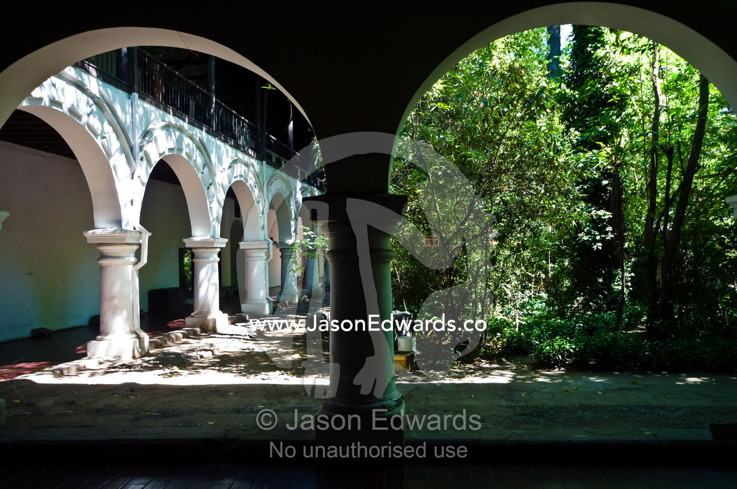 Arches lead from the covered patio of a monastery to a tranquil garden Iglesia San Francisco, Santiago, Chile