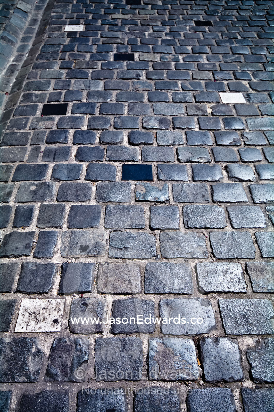 A detail of paved bluestone cobbled streets running through Santiago. Londres, Santiago, Chile