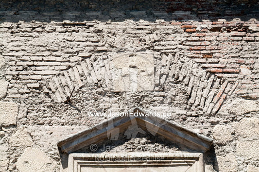 The stone wall and brick window arch to an ancient Christian church. Iglesia San Francisco, Santiago, Chile