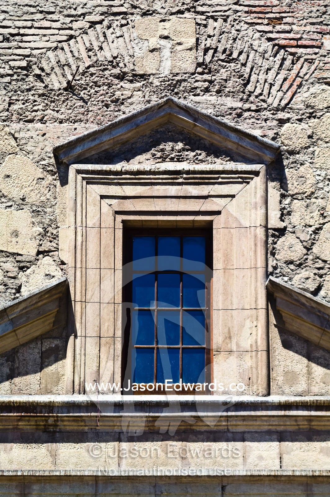The stone wall and brick window arch an ancient Christian church. Iglesia San Francisco, Santiago, Chile