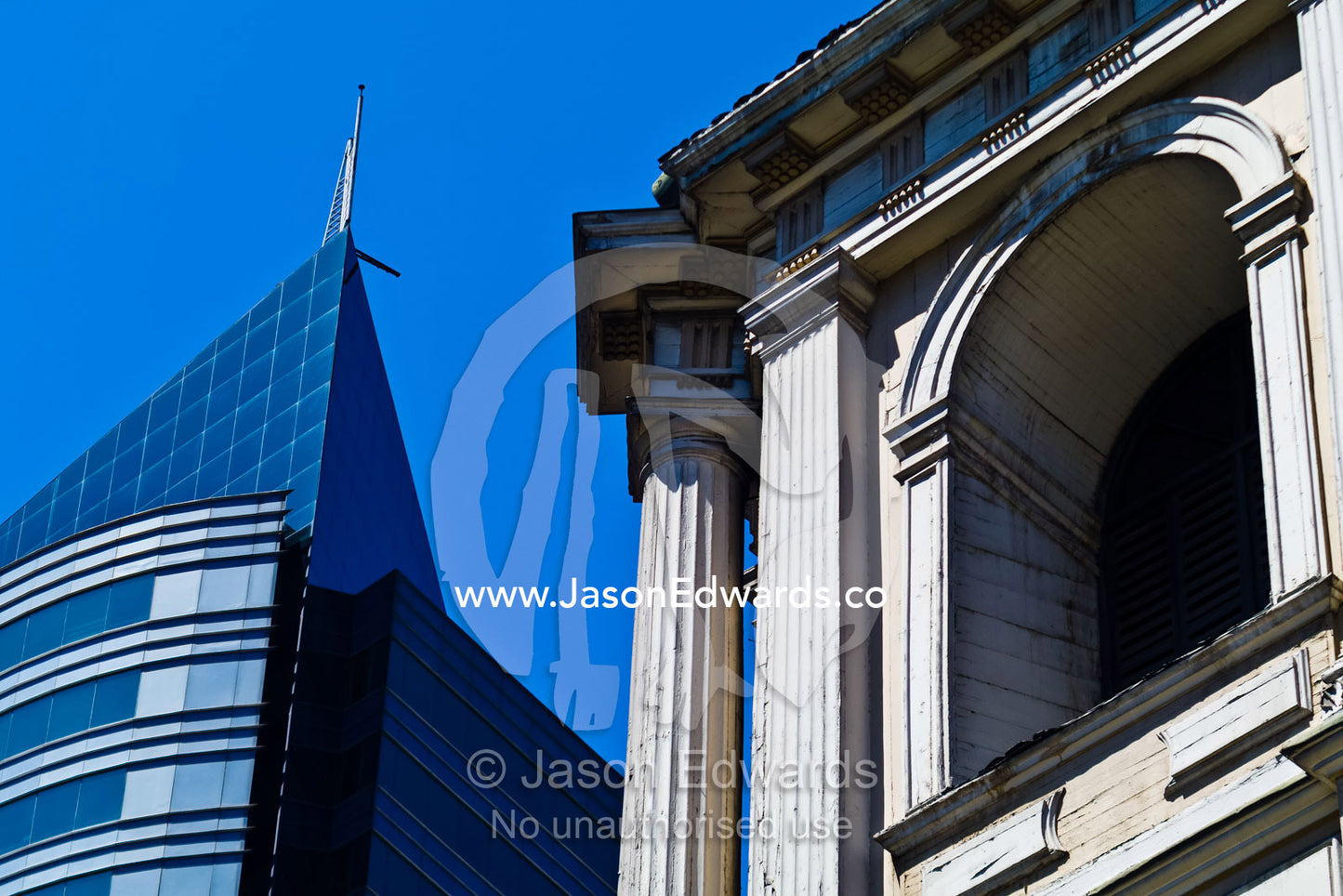 An ancient column and facade of a church near a modern office tower. Iglesia San Francisco, Santiago, Chile