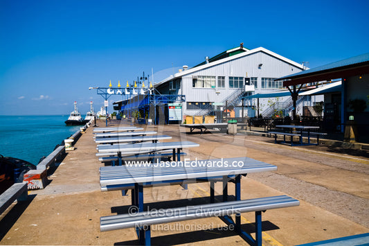 Picnic tables line a marina where tourists dine and and relax. Darwin Waterfront, Darwin, Northern Territory, Australia