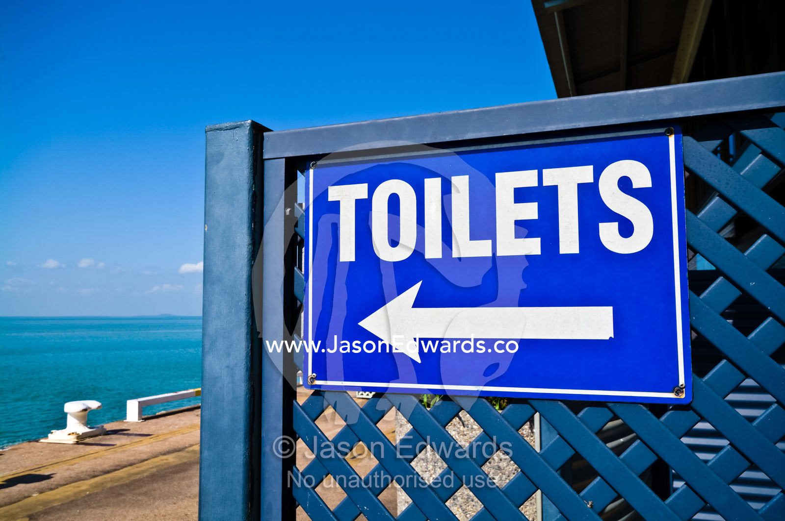 A sign and arrow directs tourists to a nearby toilet amenities block. Darwin Waterfront, Darwin, Northern Territory, Australia