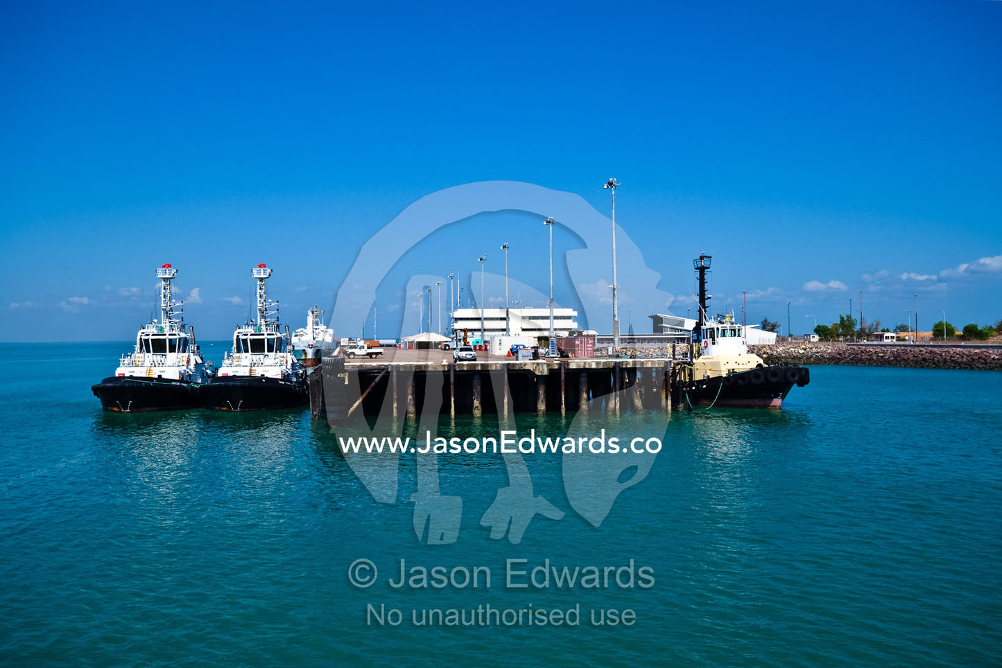 Turquoise seas and tug boats moored at a jetty in a coastal port. Darwin Waterfront, Darwin, Northern Territory, Australia
