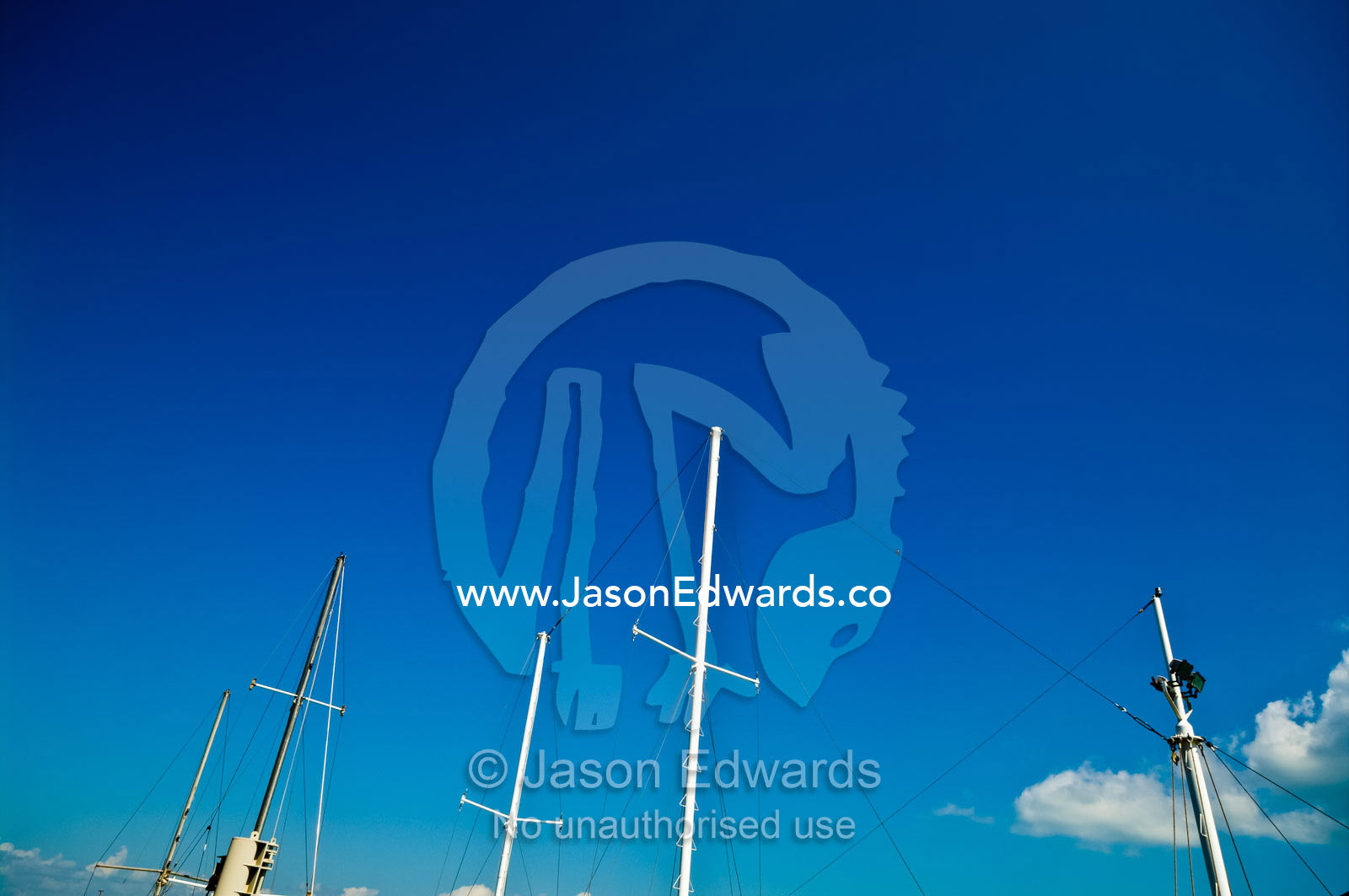 Masts with their sails lowered reach into a clear tropical blue sky. Darwin Waterfront, Darwin, Northern Territory, Australia
