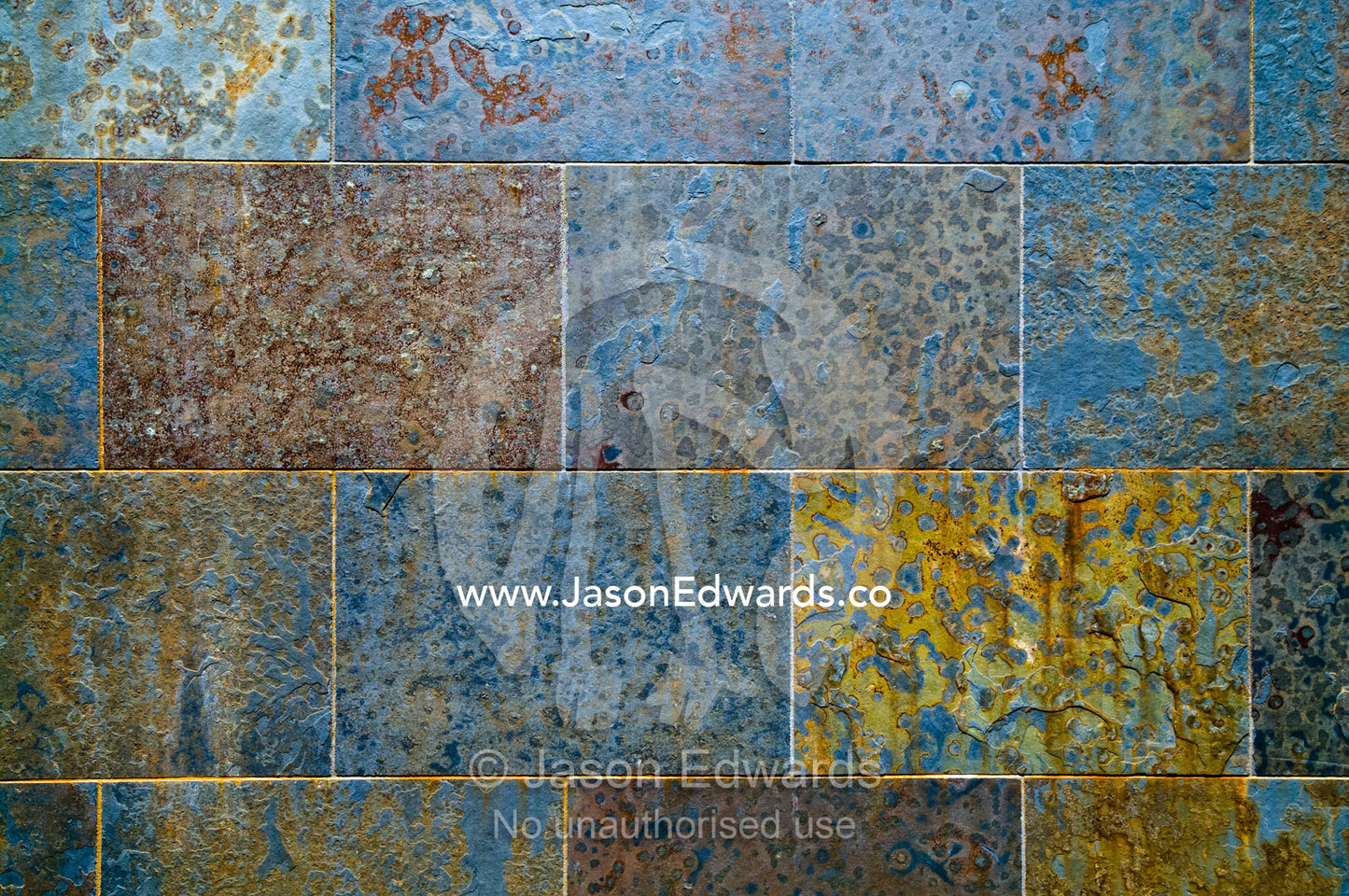Metal deposits in an architecturally designed stone wall rusting away. Darwin Waterfront, Darwin, Northern Territory, Australia