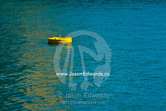 A bright yellow floating mooring buoy provides anchor in a marina. Darwin Waterfront, Darwin, Northern Territory, Australia