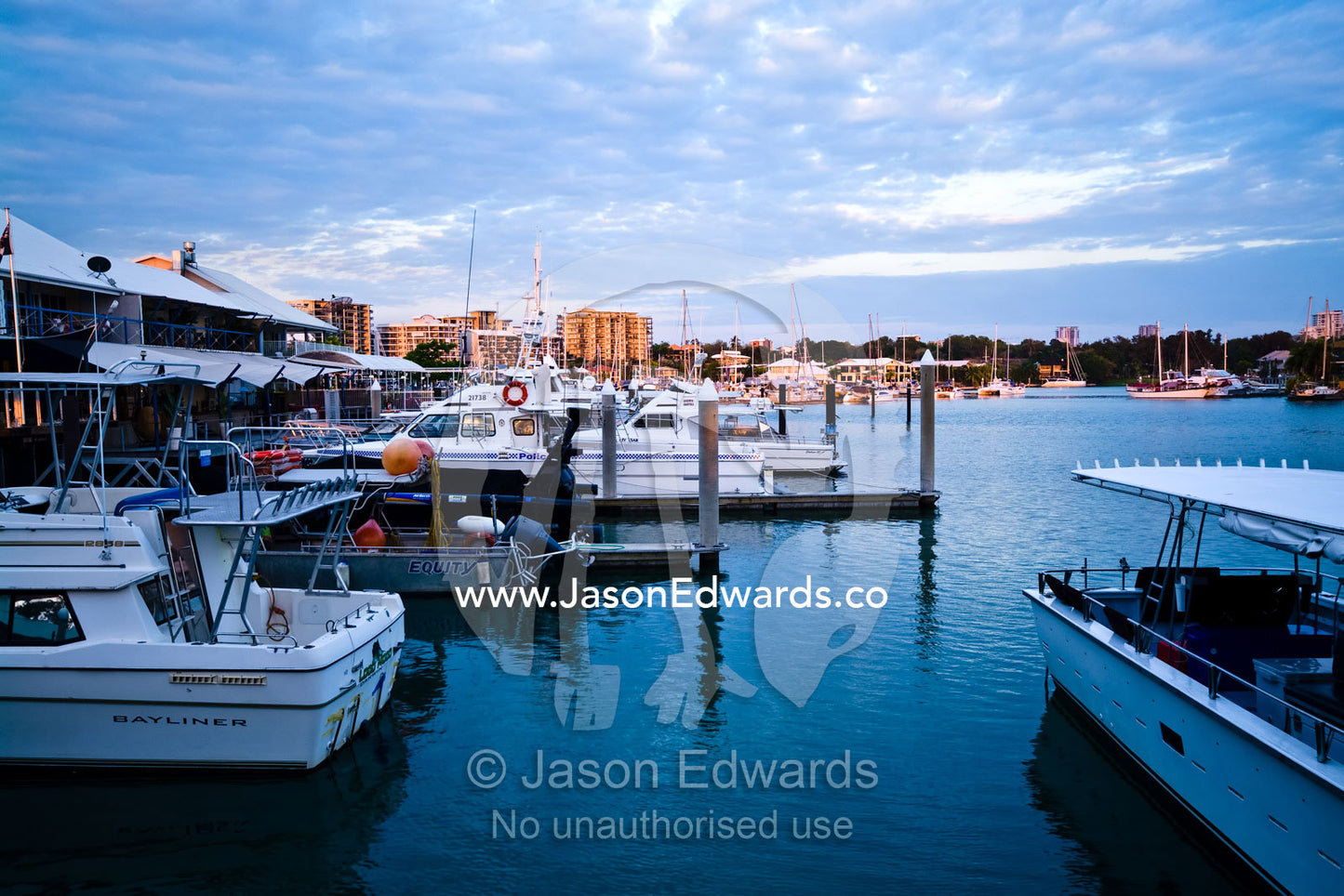 Boats moored at private jetty's in a marina surrounded by restaurants. Cullen Bay, Darwin, Northern Territory, Australia