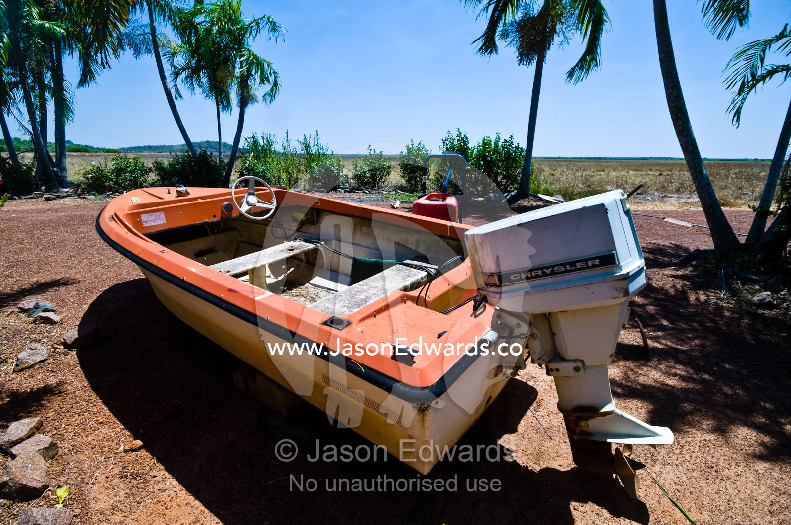 A faded old, weathered and beaten motor boat resting on dry land. Alligator River, Northern Territory, Australia