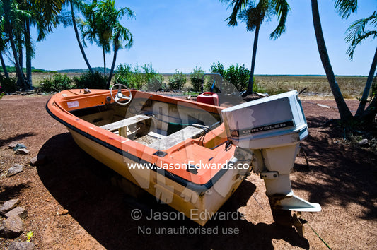 A faded old, weathered and beaten motor boat resting on dry land. Alligator River, Northern Territory, Australia