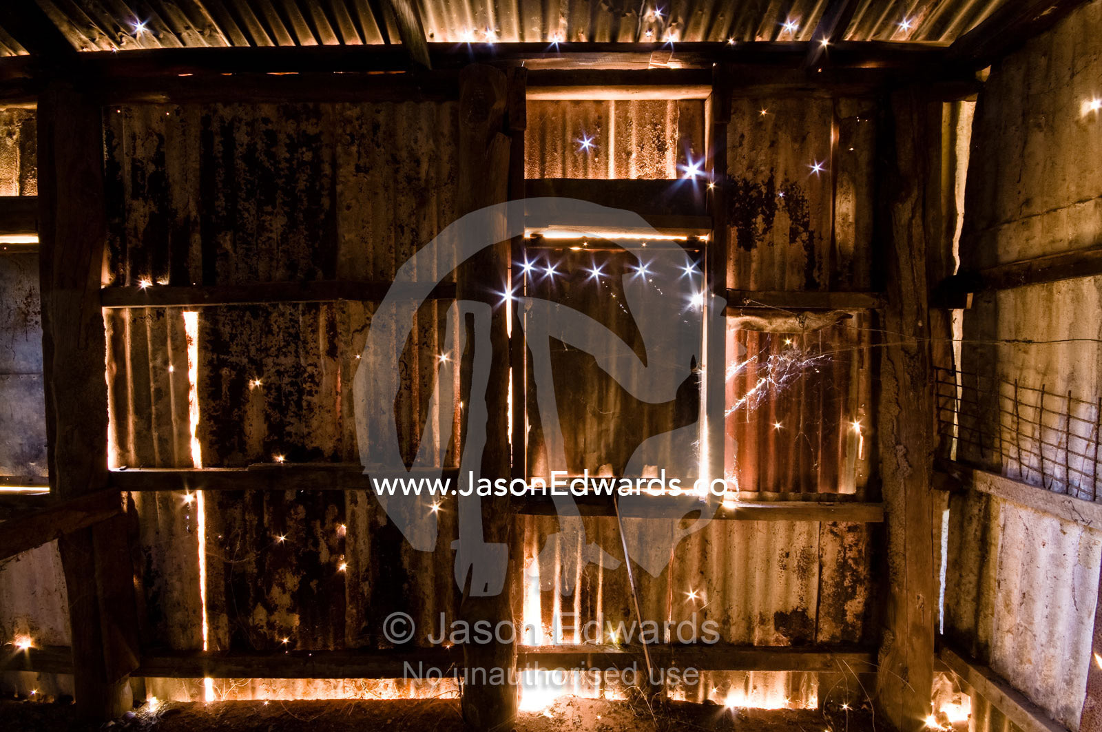 Sunlight piercing holes in a corrugated galvanized iron bakery wall. Pine Creek, Northern Territory, Australia