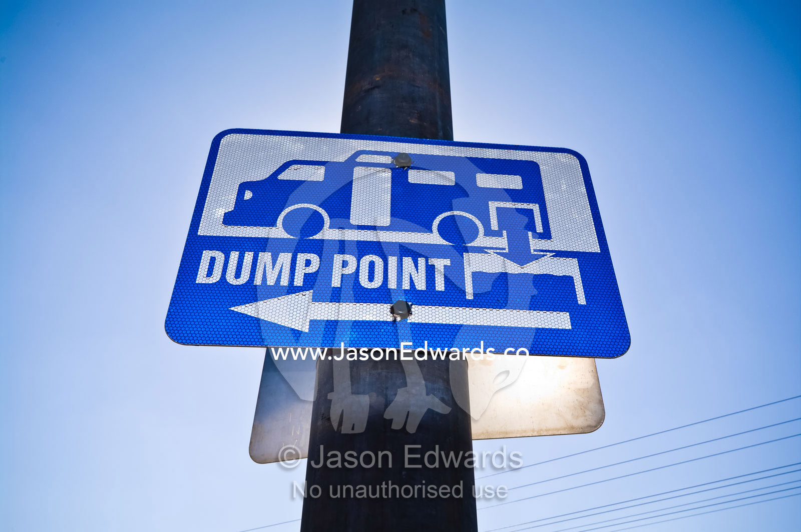 A sign mounted on a light pole directs to the local rubbish dump. Pine Creek, Northern Territory, Australia