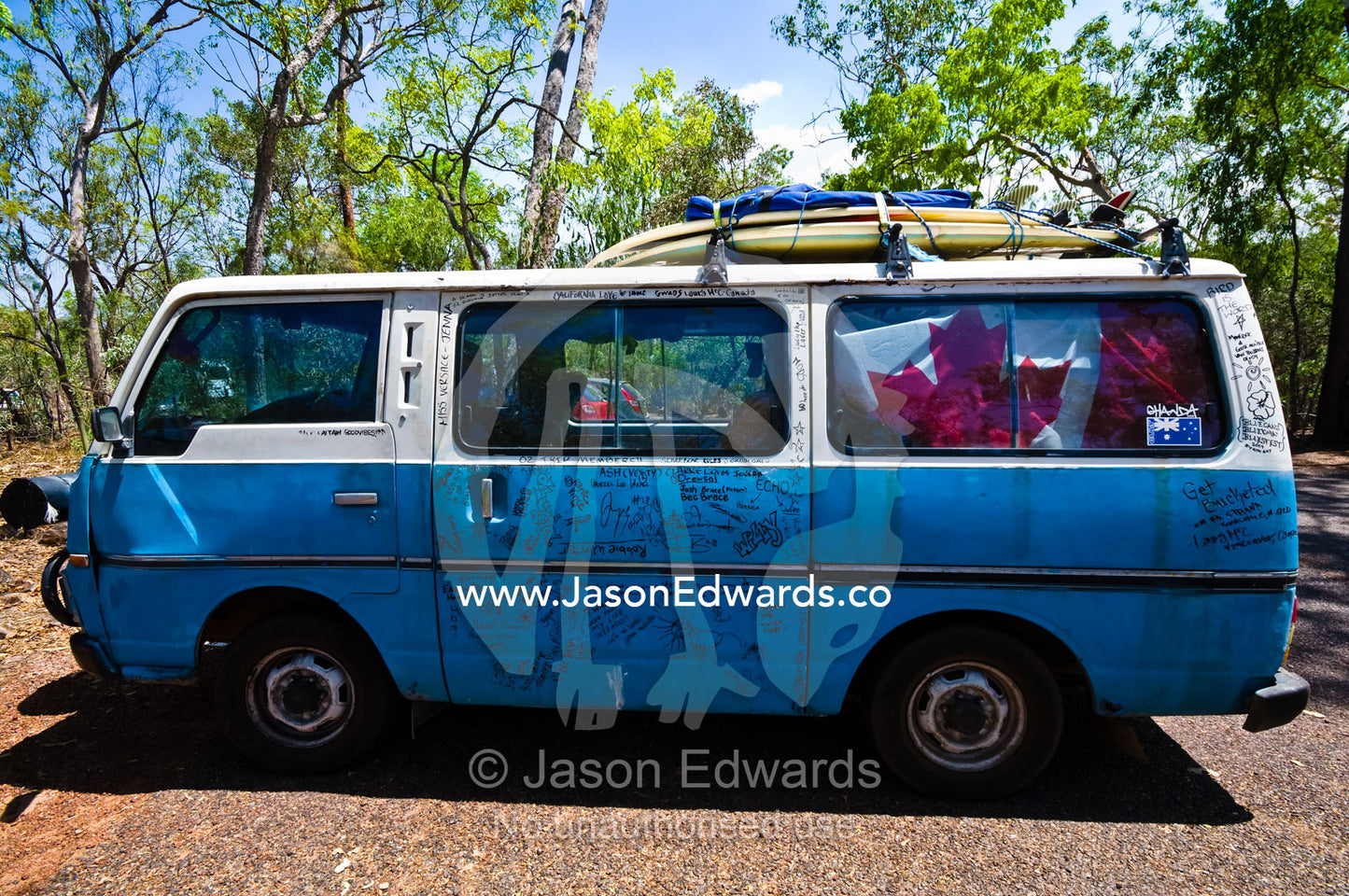 Surfboards on a Canadian backpackers camper van covered in graffiti. Litchfield National Park, Northern Territory, Australia