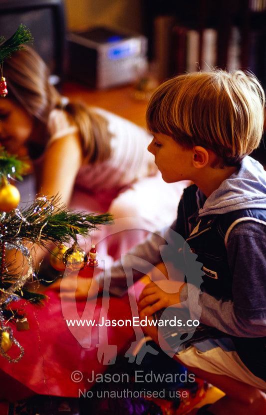 Children gather around gifts beneath a decorated tree on Christmas Day Castlemaine, Victoria, Australia