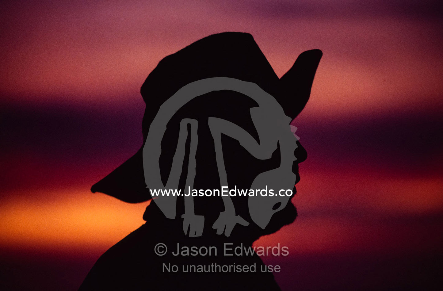 A silhouette of a rural man wearing an Akubra slouch hat. South West Conservation Area, Tasmania, Australia