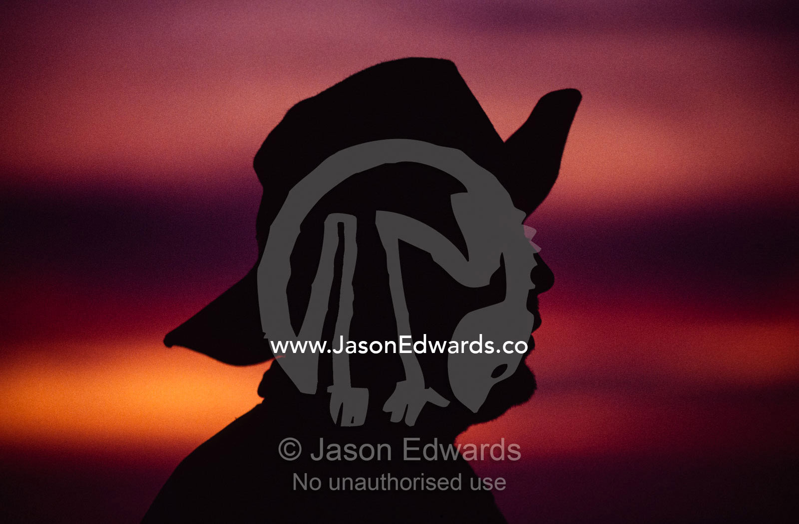 A silhouette of a rural man wearing an Akubra slouch hat. South West Conservation Area, Tasmania, Australia