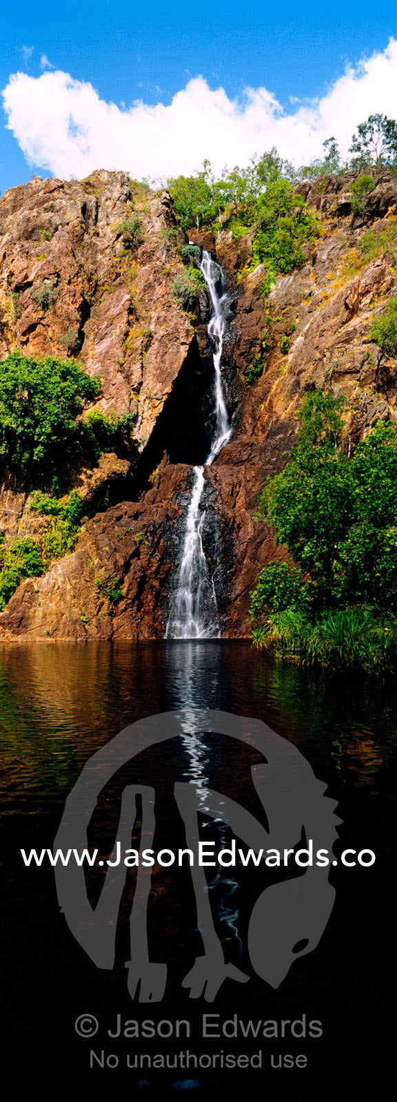 A waterfall tumbles down a rugged escarpment cliff face into a lagoon. Wangi Falls, Litchfield National Park, Northern Territory, Australia.