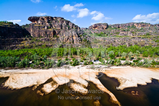 Sandbanks created by flooding Top End rivers build up beneath cliffs. East Alligator River, Arnhem Land Border, Kakadu National Park, Northern Territory, Australia.