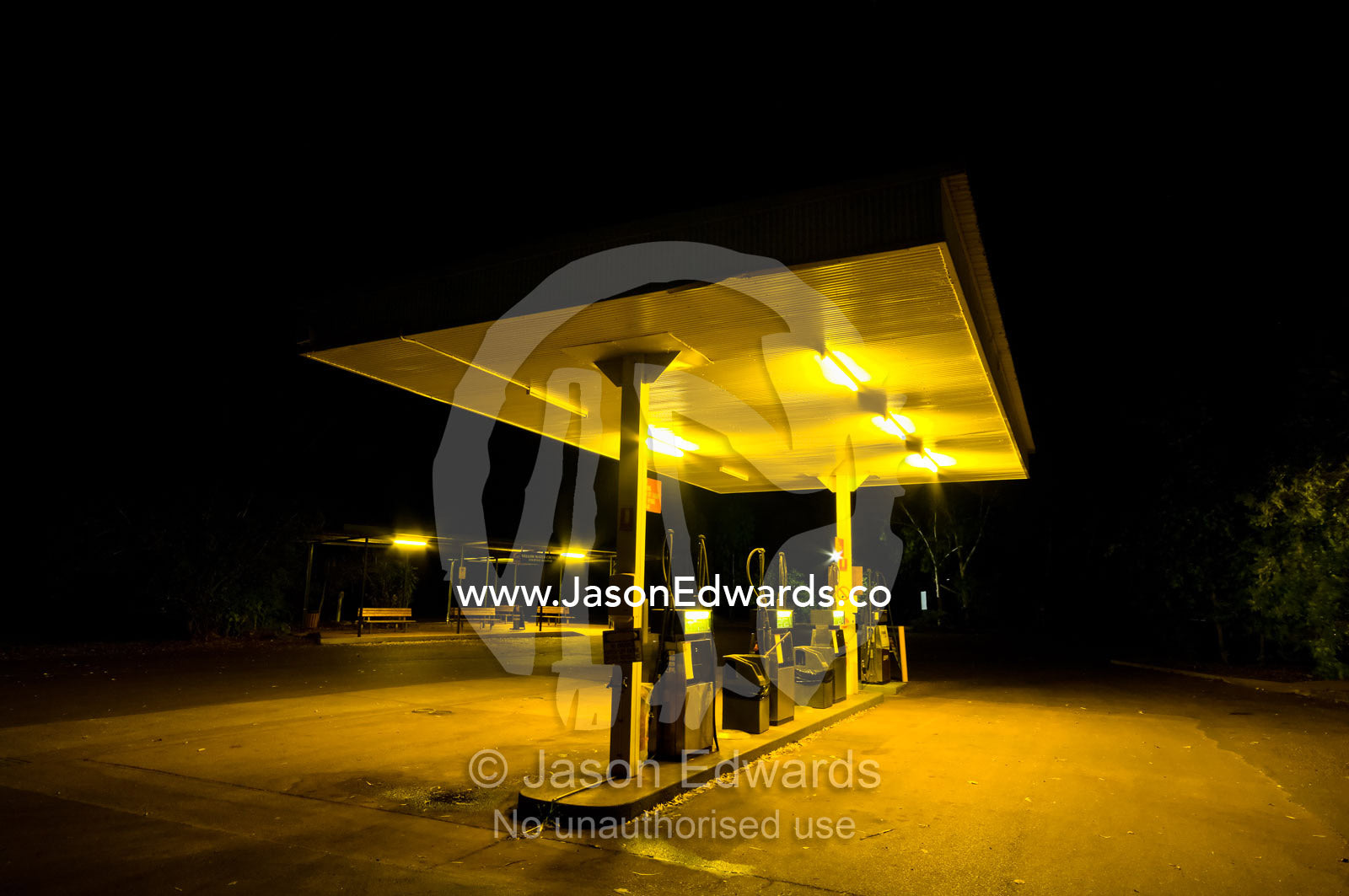 Fluorescent lights cast an eerie glow over a petrol station at night. Gagudju Cooinda Lodge, Yellow Water, Kakadu National Park, Northern Territory, Australia.