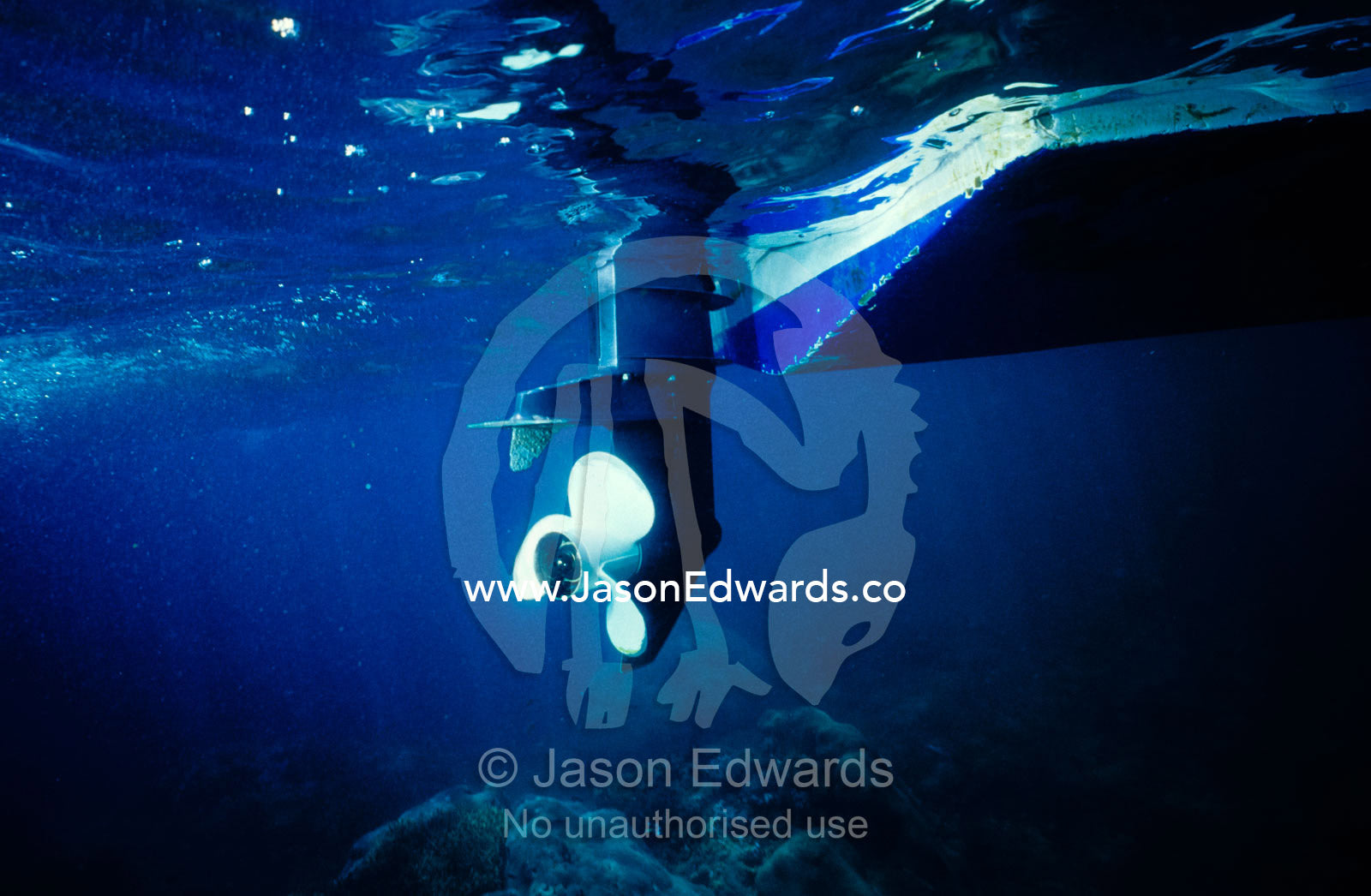 An underwater view of a boat propeller floating above a coral reef. Lombok Strait, Nusa Lembongan, Bali, Indonesia.