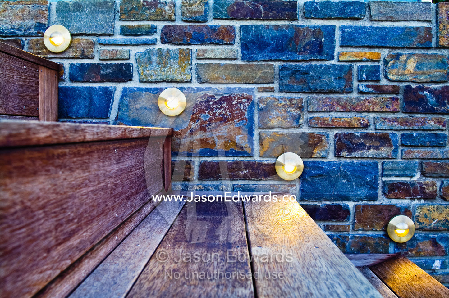 Artificial lighting illuminates a stone wall and Merbau timber steps. Red Hill, Mornington Peninsula, Victoria, Australia.