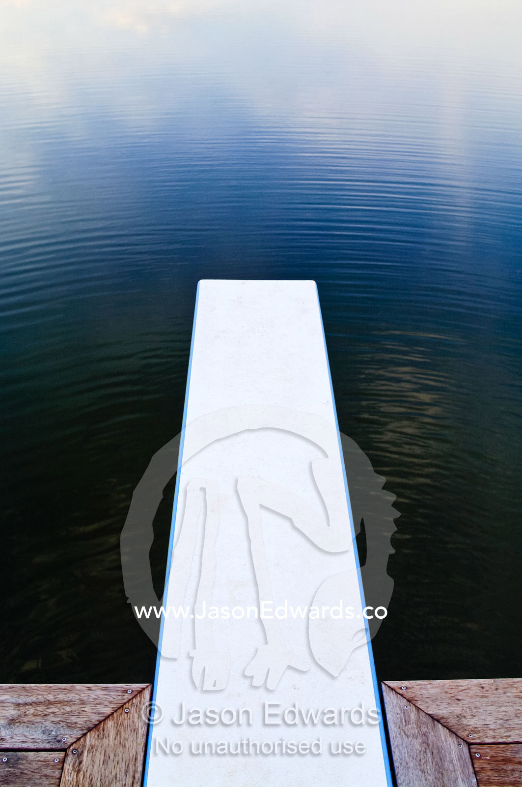 A Merbau deck and diving board over a swimming hole at sunset. Red Hill, Mornington Peninsula, Victoria, Australia.