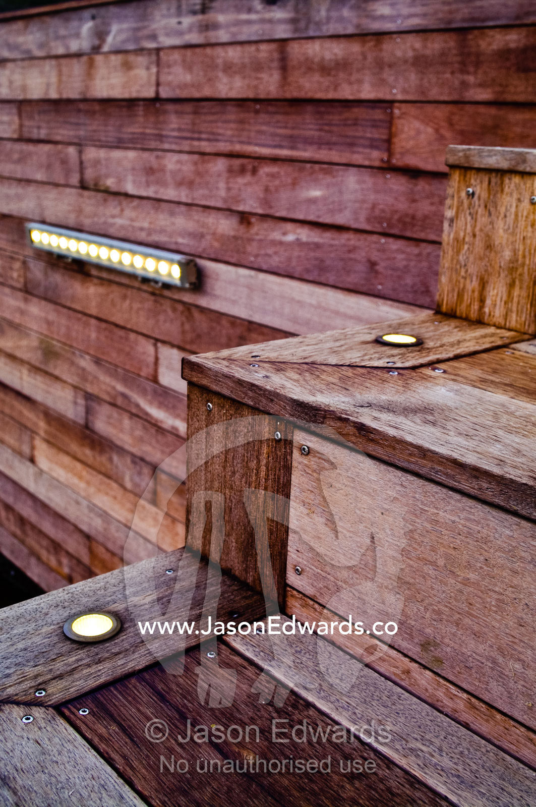 Brass lighting fixtures illuminate a set of Merbau timber steps. Red Hill, Mornington Peninsula, Victoria, Australia.