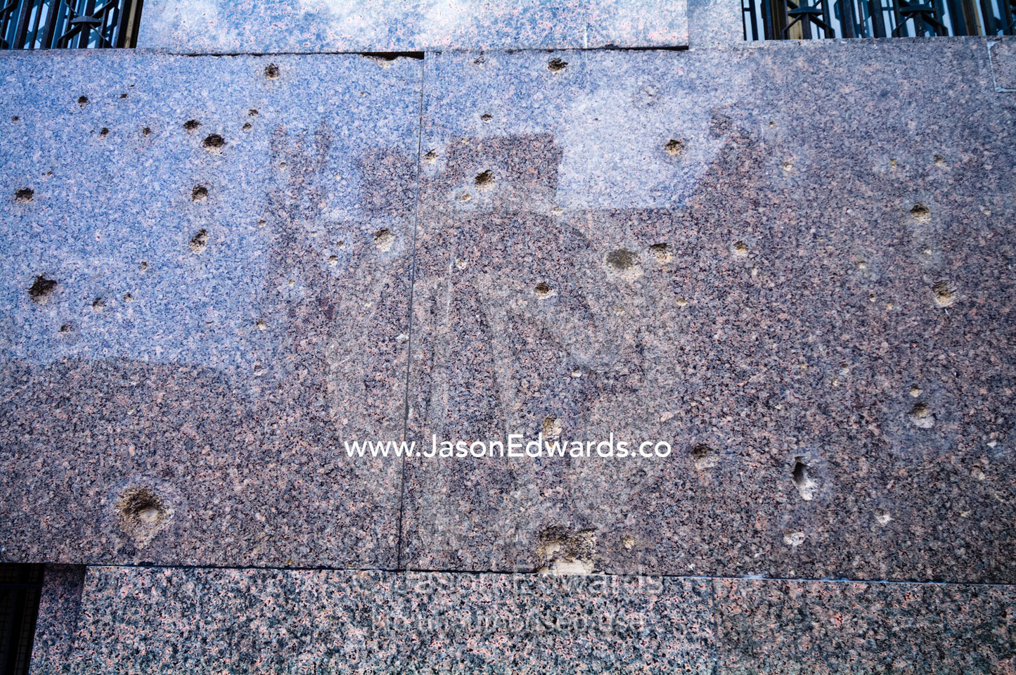 Bullet holes shatter the marble facade of an office building. near Plaza de Mayo, Buenos Aires, Argentina.