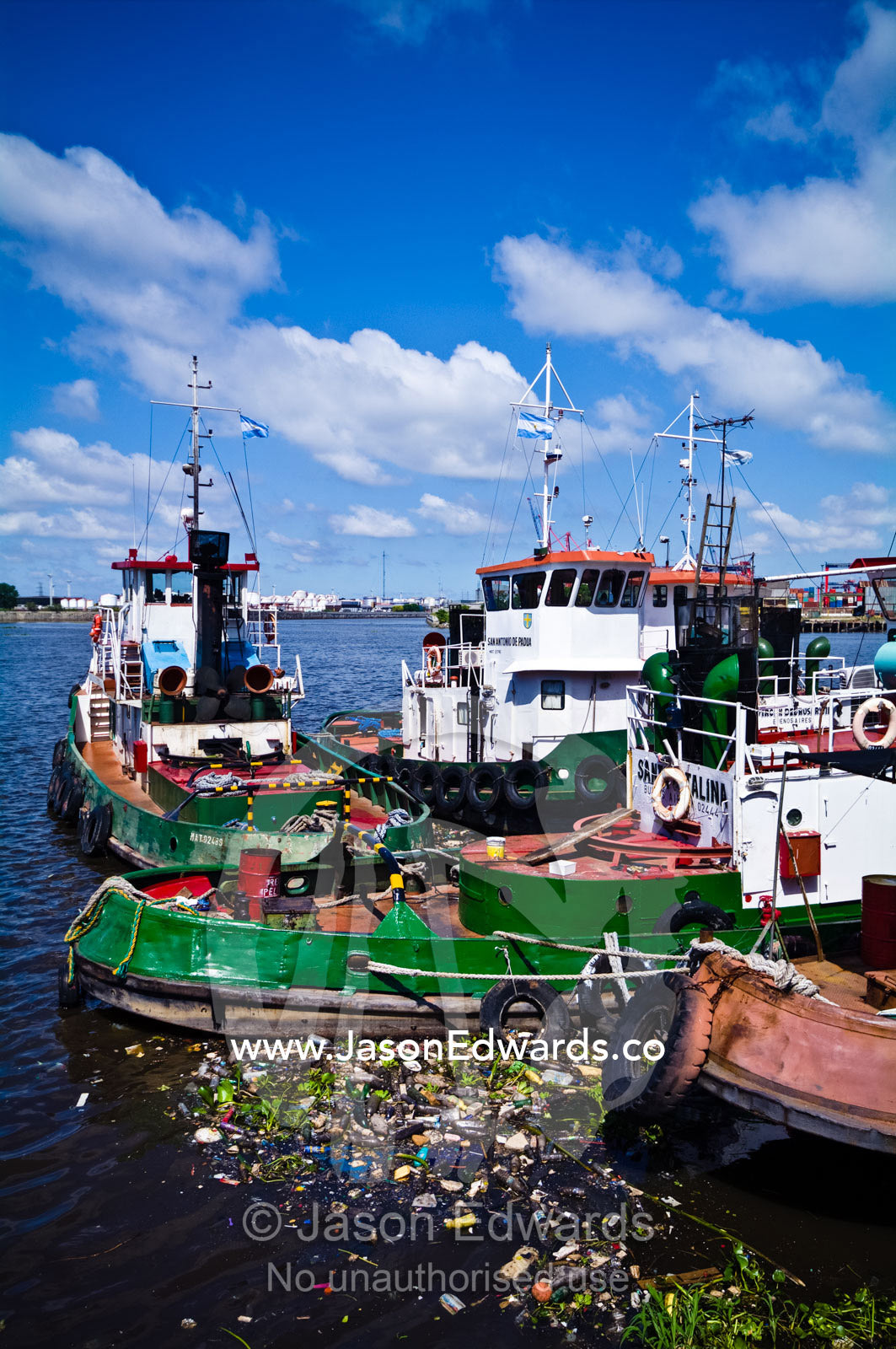 Pollution collects around tugboat hulls moored on the Riachuelo River. La Riachuelo, Little River, La Boca, Buenos Aires, Argentina.
