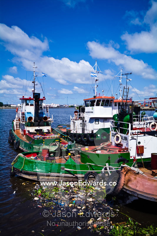 Pollution collects around tugboat hulls moored on the Riachuelo River. La Riachuelo, Little River, La Boca, Buenos Aires, Argentina.
