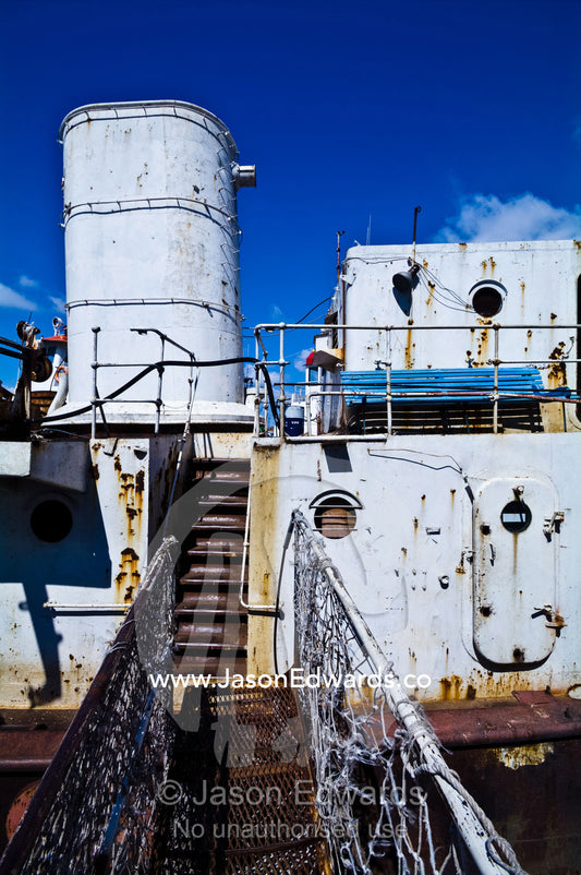 A rickety gangplank leads to the rusting deck of an old river boat. La Riachuelo, Little River, La Boca, Buenos Aires, Argentina.
