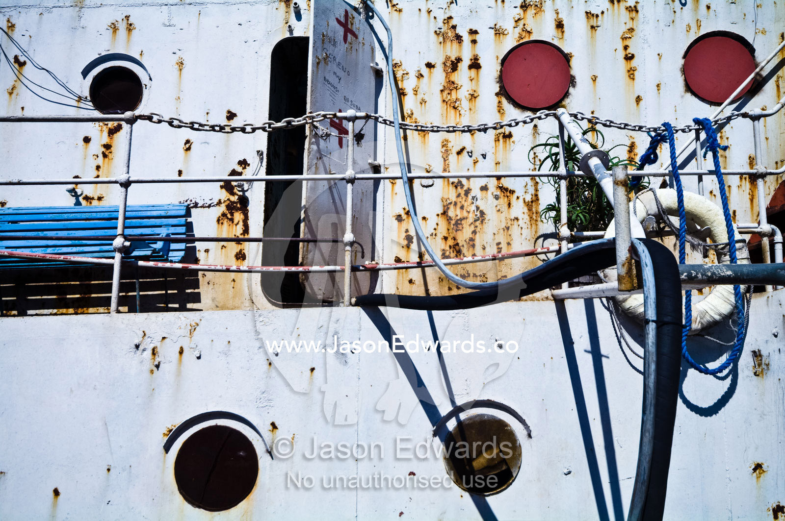 Rusted portholes and pitted steel of an old river boat steam tramper. La Riachuelo, Little River, La Boca, Buenos Aires, Argentina.
