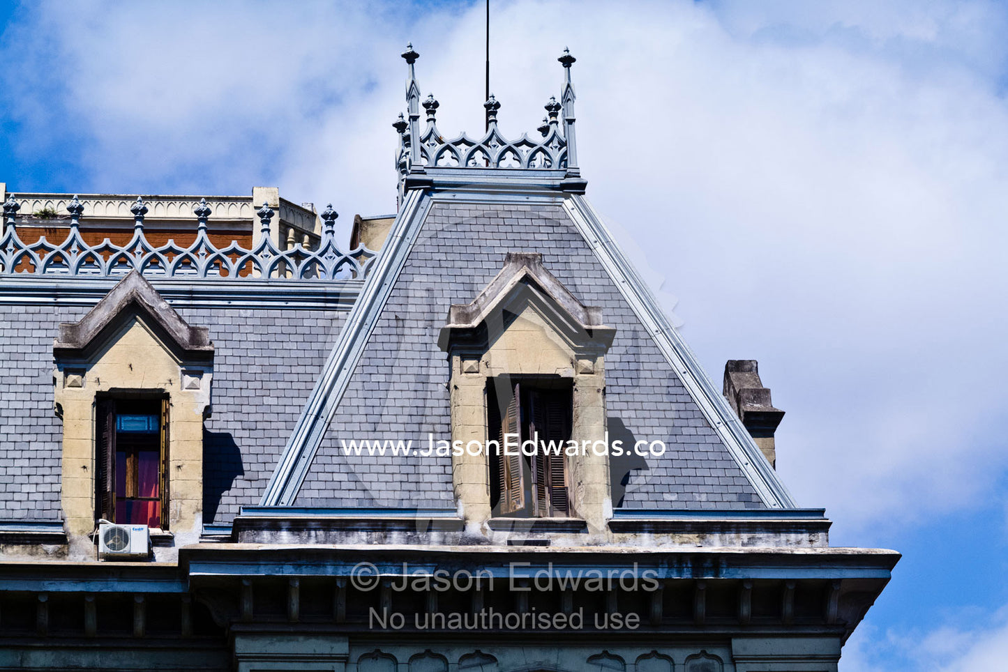 Cast iron filigree and shuttered windows on a pitched slate roof. San Telmo, Buenos Aires, Argentina.
