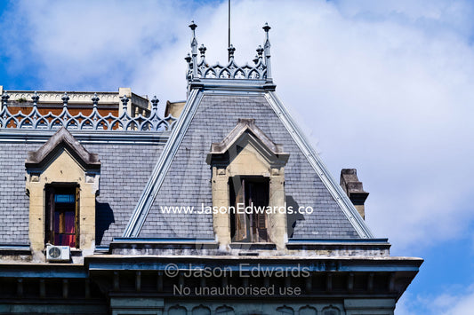 Cast iron filigree and shuttered windows on a pitched slate roof. San Telmo, Buenos Aires, Argentina.