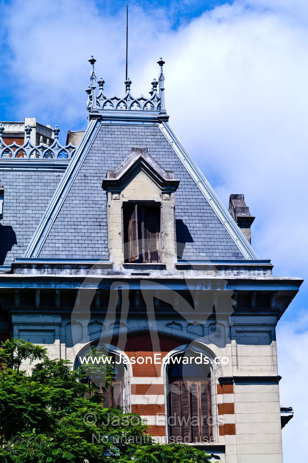 Cast iron filigree and shuttered windows on a pitched slate roof. San Telmo, Buenos Aires, Argentina.