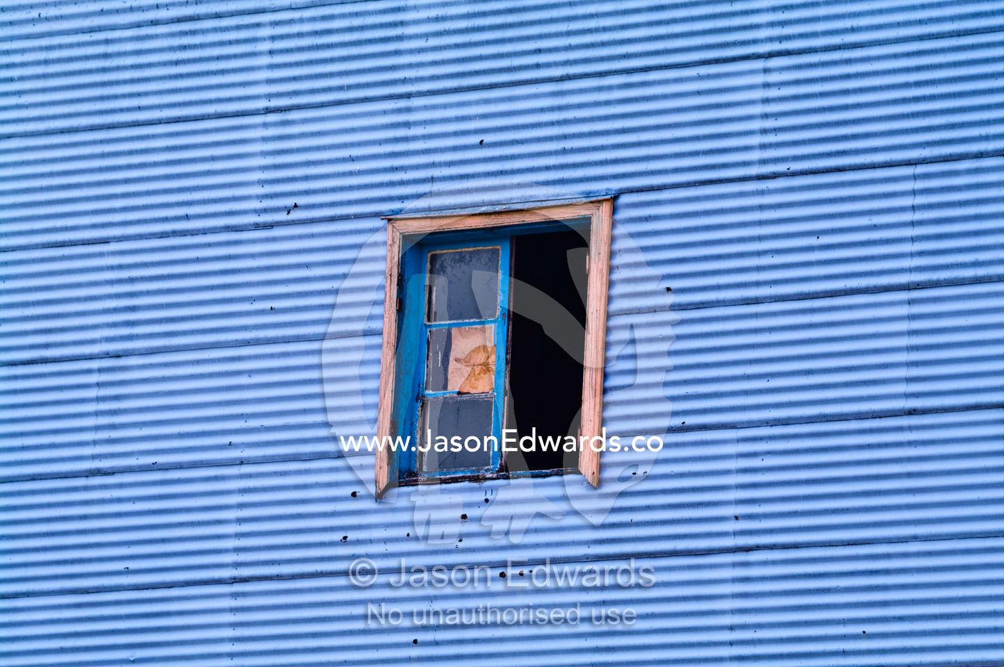 An open window in a blue corrugated tin wall. El Caminito, La Boca, Buenos Aires, Argentina.