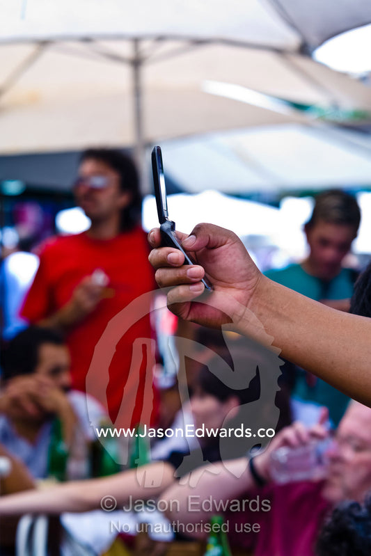 A person holds a mobile phone camera to capture a photograph and text. El Caminito, La Boca, Buenos Aires, Argentina
