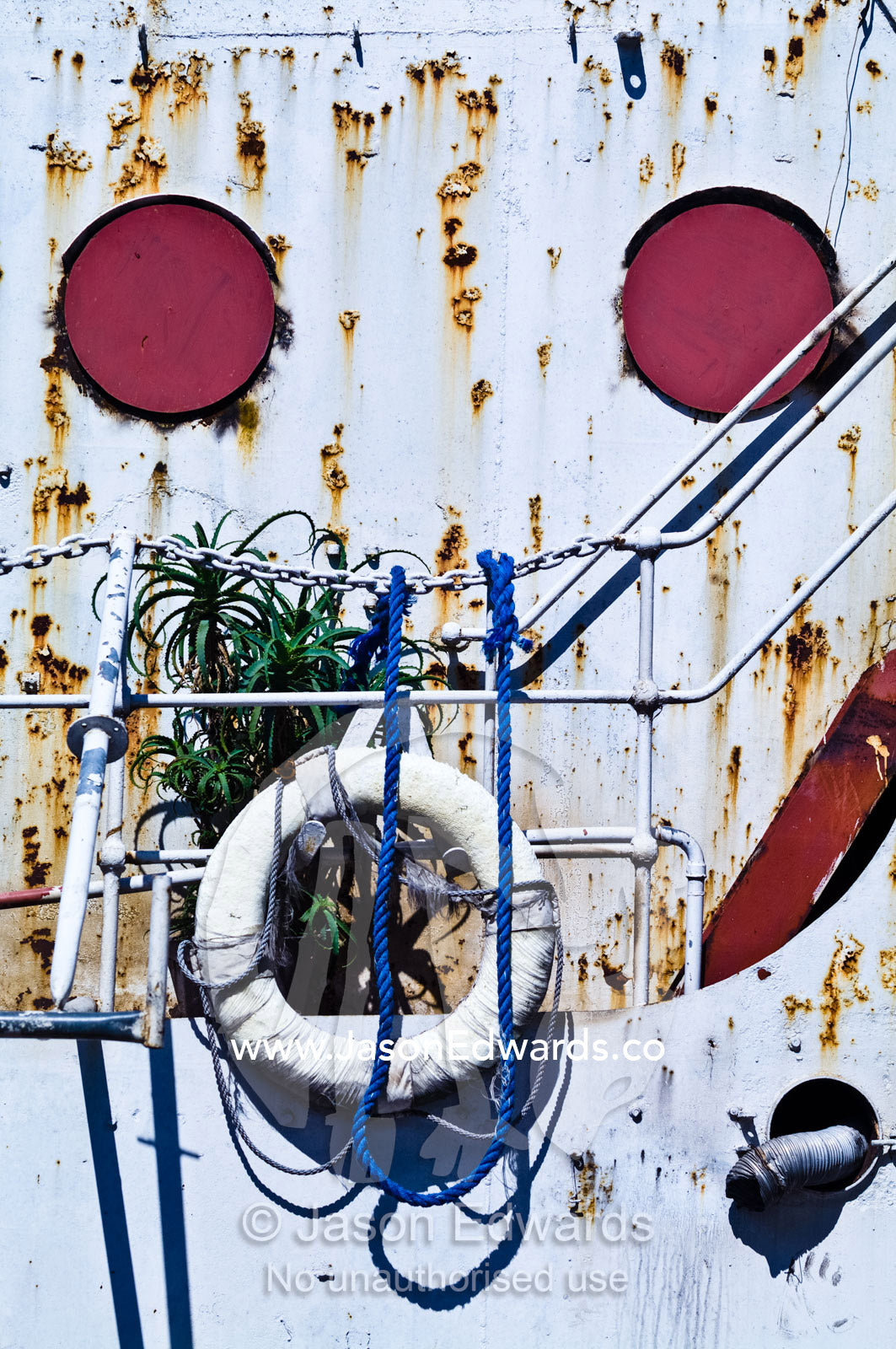 An old river boats rusted portholes, pitted steel and lifesaving ring. La Riachuelo, Little River, La Boca, Buenos Aires, Argentina.