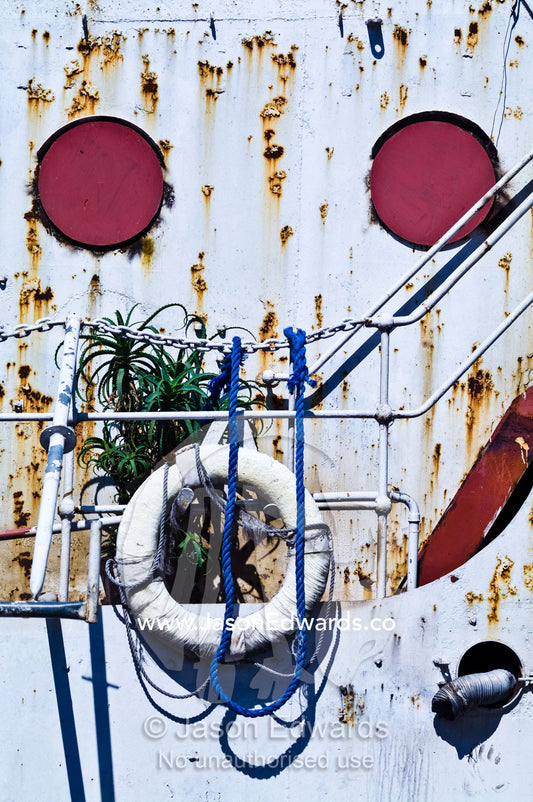 An old river boats rusted portholes, pitted steel and lifesaving ring. La Riachuelo, Little River, La Boca, Buenos Aires, Argentina.