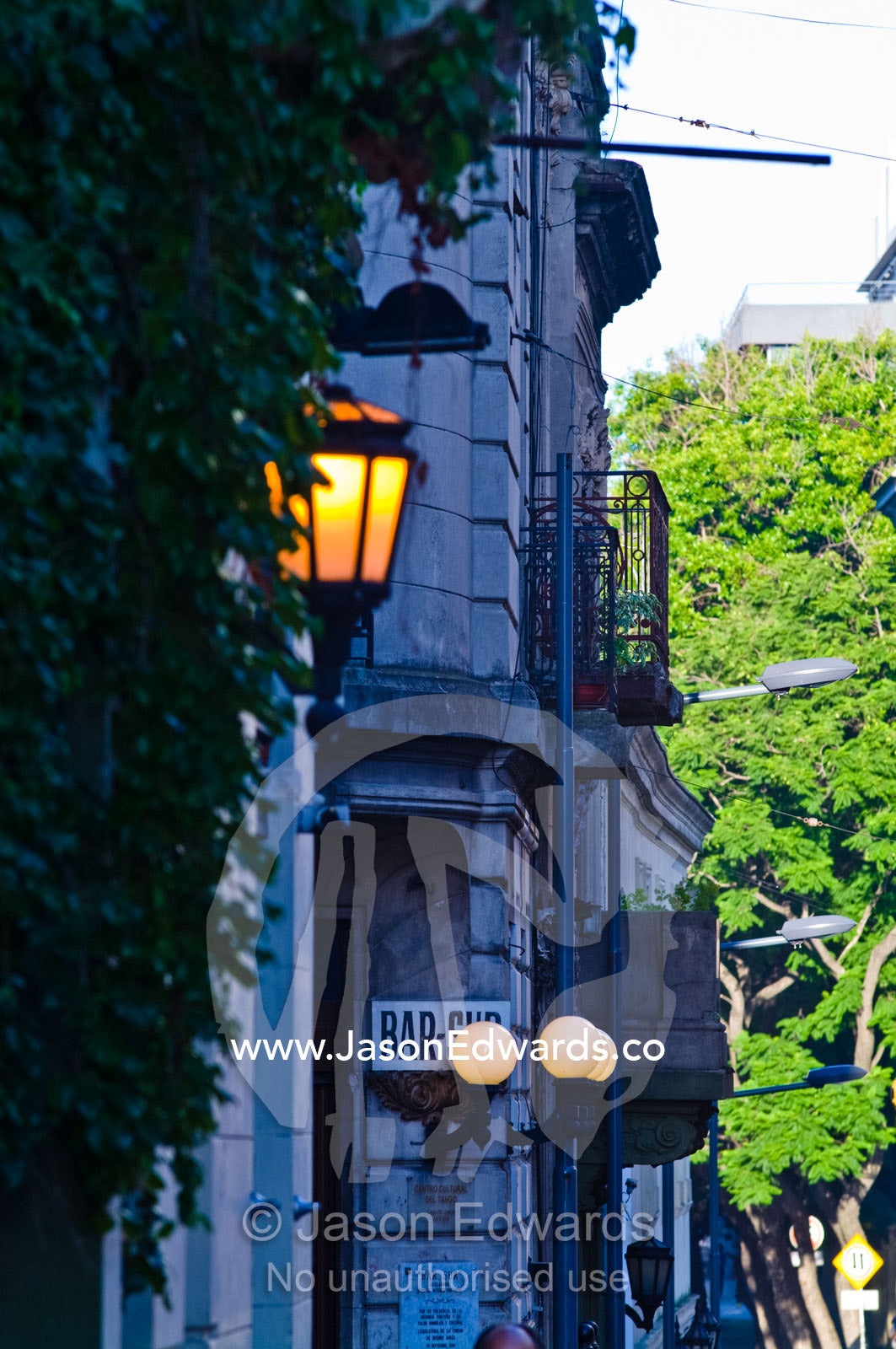Antique lamps illuminate a street lined with bars and cafes. San Telmo, Buenos Aires, Argentina.