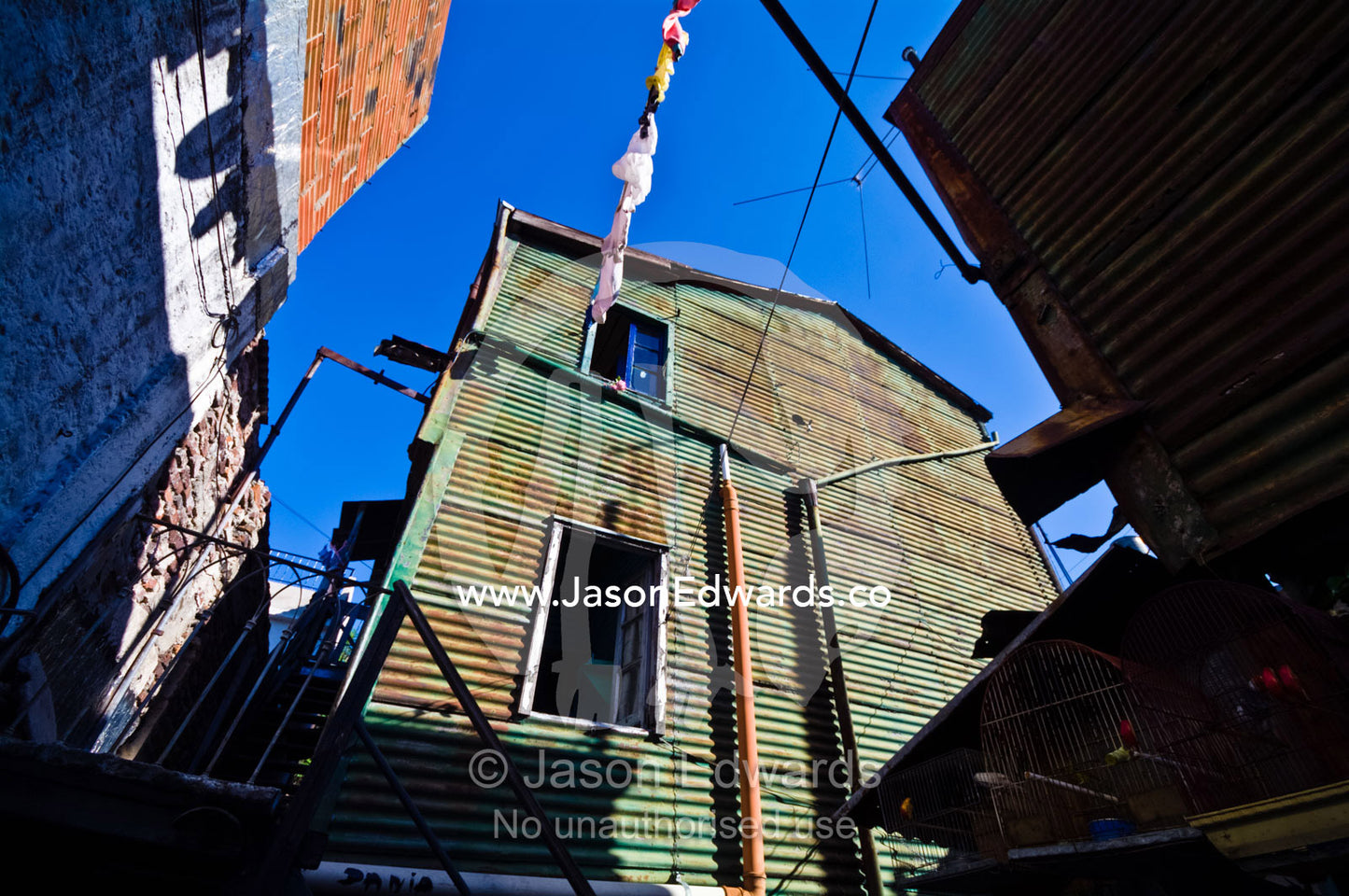 Several poor families live together in a corrugated tin conventillo. La Boca, Buenos Aires, Argentina.