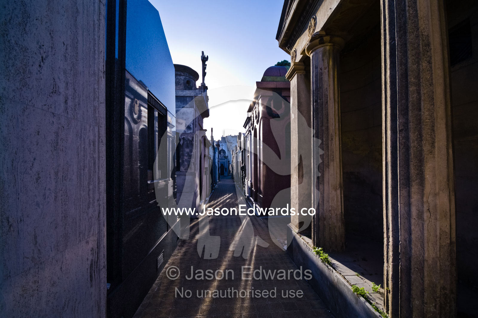 Tiles pave the alleyways between family mausoleums in a city cemetery. La Recoleta Cemetery, Recoleta, Buenos Aires, Argentina.