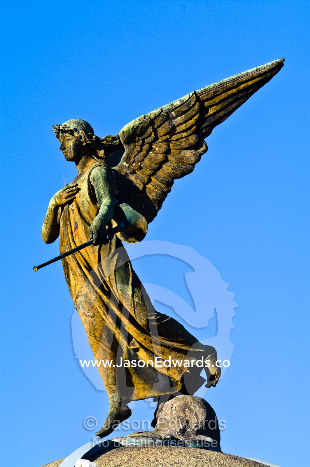 An oxidising brass statue of an angel on the roof of a mausoleum. La Recoleta Cemetery, Recoleta, Buenos Aires, Argentina.